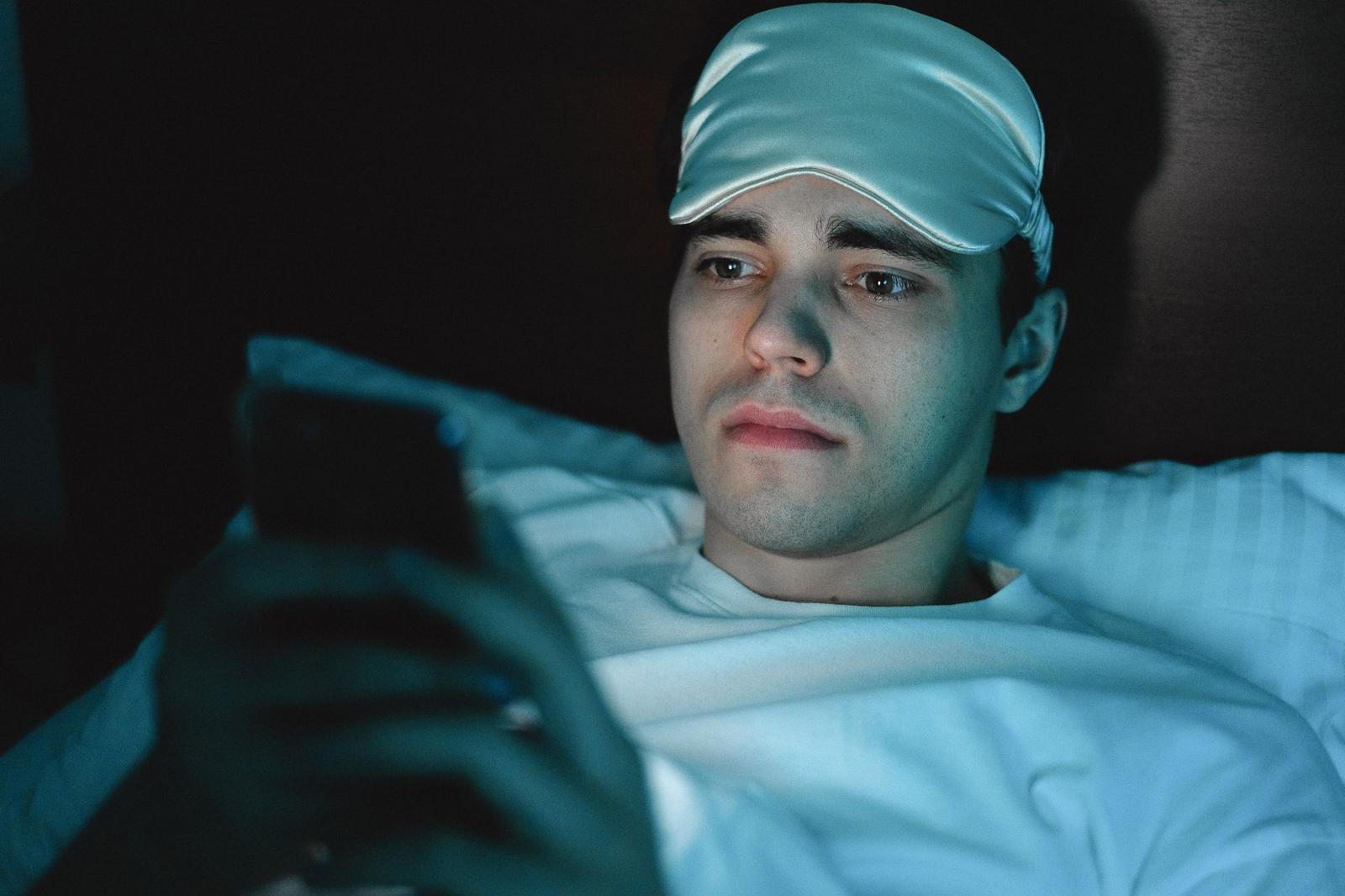 A Man in White Shirt with Sleeping Mask on His Head